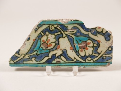Randtegel, fragment, met decor van florale motieven en arabesken